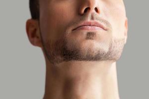 Handsome man. Cropped image of handsome young beard man isolated on grey background photo