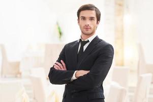 Confident in his future. Confident young man in formalwear keeping arms crossed and looking at camera photo