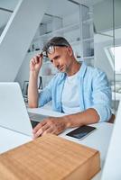 Tired mature man working on laptop while sitting at the office desk photo