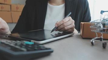 joven mujer de negocios asiática que usa una llamada de teléfono móvil que recibe una orden de compra y verifica el producto en stock, trabaja en la oficina de su casa. Entrega de mercado en línea para pequeñas y medianas empresas, concepto independiente de estilo de vida. video