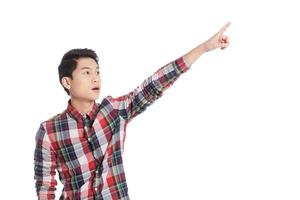Look over there Surprised Chinese teenage boy pointing away while standing isolated on white photo