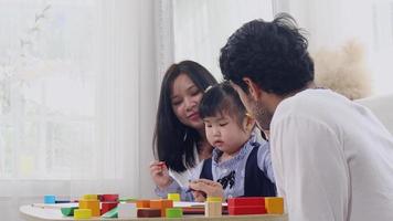 asiatisk familjer lyckligt spelar trä- sticksågar. kärlek, värma familj obligationer video