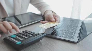 Woman hands holding and using cradit card for shopping online. video