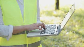 intelligenter asiatischer arbeiter oder männlicher bauingenieur mit schutzhelm und reflektierender weste mit digitalem tablet zur projektplanung und prüfung der bauzeichnung auf der baustelle. video