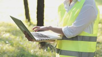 inteligente asiatico lavoratore uomo o maschio civile ingegnere con protettivo sicurezza casco e riflessivo veste utilizzando digitale tavoletta per progetto pianificazione e controllo architettonico disegno a costruzione luogo. video