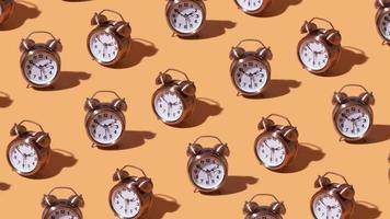 un' in movimento modello di un allarme orologio su un arancia sfondo. creativo tempo concetto. alto qualità 4k metraggio video