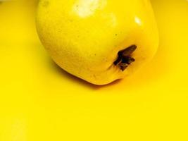 Juicy quince. Fruit on a yellow background. Ripe useful product. photo