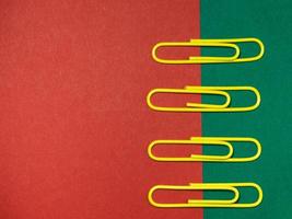 Colored paper clips on paper. Office supplies. Business goods. photo