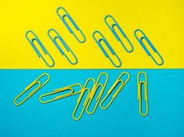 Colored paper clips on paper. Office supplies. Colorful office supplies. photo