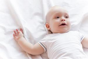 Cute little baby. Top view of cute little baby lying in bed photo
