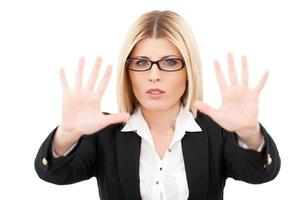 Stop it Confident mature businesswoman gesturing stop sign while standing isolated on white photo