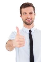 Good job Confident young man in formalwear stretching out hand with thumb up while standing isolated on white photo