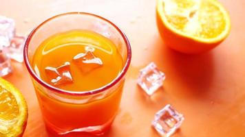 Sliced orange halves and juice with ice
