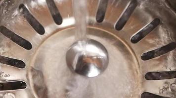 Close up of water running down a sink strainer into the drain video