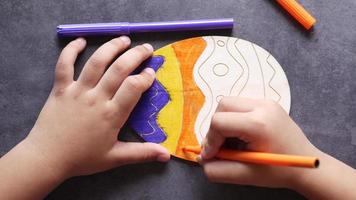Kind färbt hölzernes Eihandwerk mit Markierung video