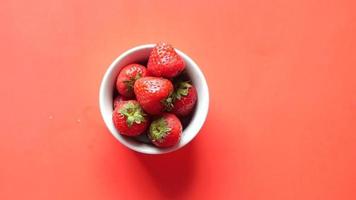 Red ripe strawberry is picked up from a ceramic dish video