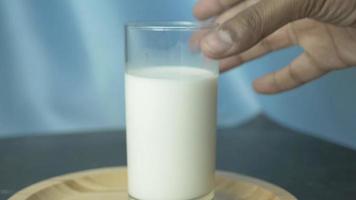 Glass of milk picked up by right hand lifted out of frame video