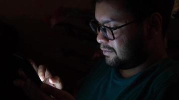 uomo con bicchieri usi smartphone nel il buio video