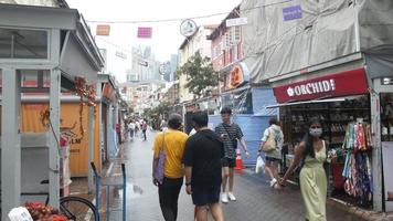 menschen mit gesichtsmasken gehen in chinatown, singapur, eine straße entlang video