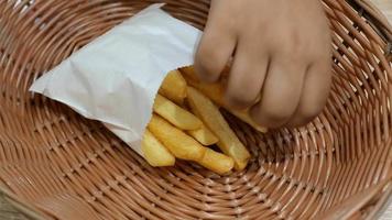 Taking a french fry out of a paper bag