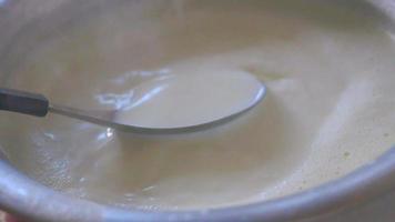 Spoon stirs hot milk steaming in a bowl video