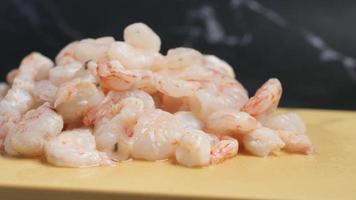 dégel de crevettes crues sur une surface jaune video