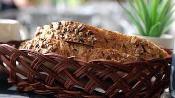 Slices of artisan seeded bread in a basket next to a cup of coffee or tea video