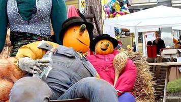 muñeco de calabaza apoyado en la silla. en medio de la multitud de la ciudad video