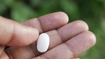 Close up of man holding round pills in palm of hand video