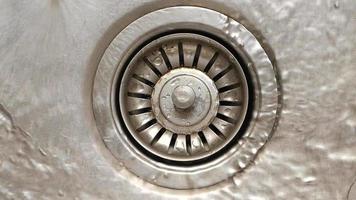 Close up of water running down a sink strainer into the drain video