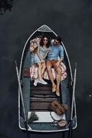 pareja de moda. vista superior de una hermosa pareja joven con anteojos abrazándose mientras yacía en el bote foto