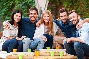 The best friends ever Group of joyful young people bonding to each other and looking at camera while having good time together photo