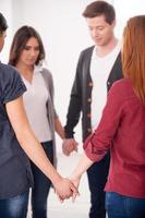 Unity and support. Group of people standing in circle and holding hands together photo