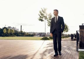 Full length of confident mature man in full suit walking outdoors photo