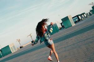 juguetón. mujer joven atractiva que se siente libre mientras corre al aire libre foto