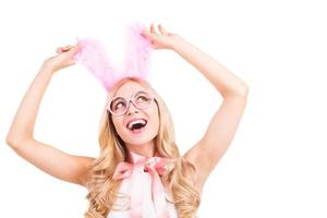 My ears are so cute. Happy young blond hair woman with rabbit ears gesturing and smiling while standing isolated on white background photo