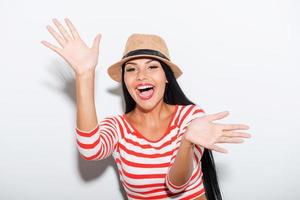 Playful and carefree. Playful young woman stretching out her hands while standing against white background photo