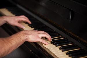 Hands of a genius. Close-up shoot of hands touching piano keys photo