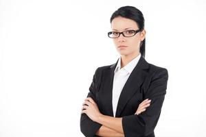 Confident businesswoman. Confident young business woman looking at camera and keeping her arms crossed while standing isolated on white photo