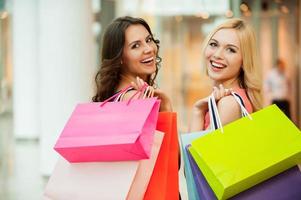 amigos felices comprando. dos hermosas mujeres jóvenes disfrutando de las compras en el centro comercial foto