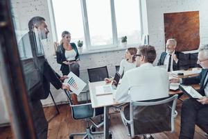 Successful business team analyzing sales while having staff meeting in the board room photo