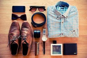 The most important things. Top view of clothing and diverse personal accessory laying on the wooden grain photo