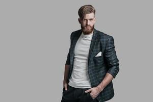 Ready to go Handsome man with long hair and beard looking at camera while standing against grey background photo