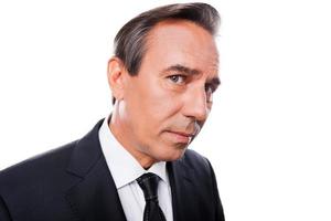 Curious businessman. Wide-angle image of mature man in formalwear looking at camera while standing isolated on white background photo