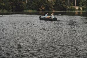 Stress free zone. Beautiful young couple having romantic date while rowing a boat photo