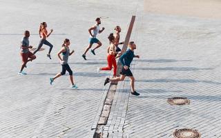 Full length top view of young people in sports clothing jogging while exercising outdoors photo