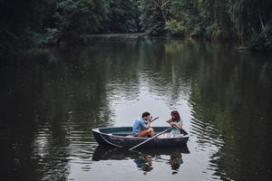 tomando un gran tiro. vista superior de un joven fotografiando a su hermosa novia mientras disfruta de una cita romántica en el lago foto