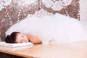 Soapy pleasure. Beautiful young woman relaxing in Turkish bath with foam photo