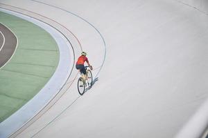 Top view of man in sports clothing cycling on track outdoors photo