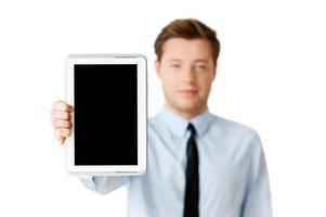 Copy space on his tablet. Confident young man in formalwear showing his digital tablet while standing isolated on white photo